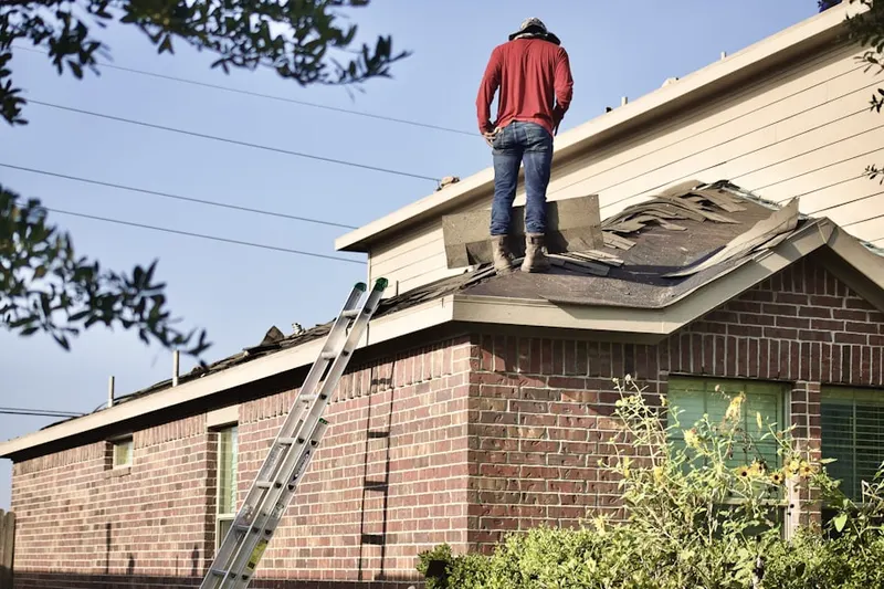 Professional roofer working on a residential roof in Carlos
